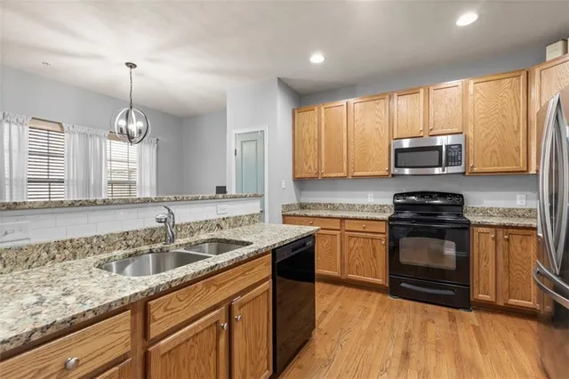 a kitchen with granite countertop a sink stainless steel appliances and cabinets