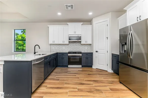 a kitchen with stainless steel appliances granite countertop a stove a sink and a refrigerator