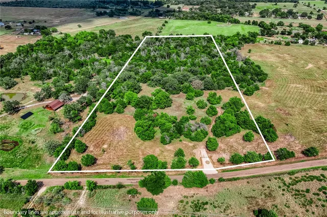 an aerial view of a residential houses with yard