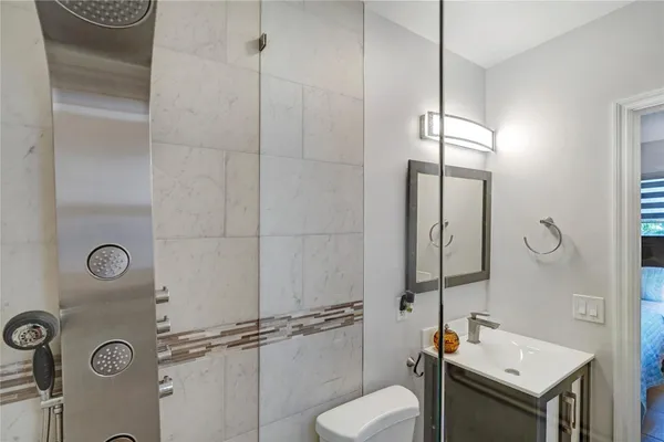 a bathroom with a granite countertop sink a toilet and shower