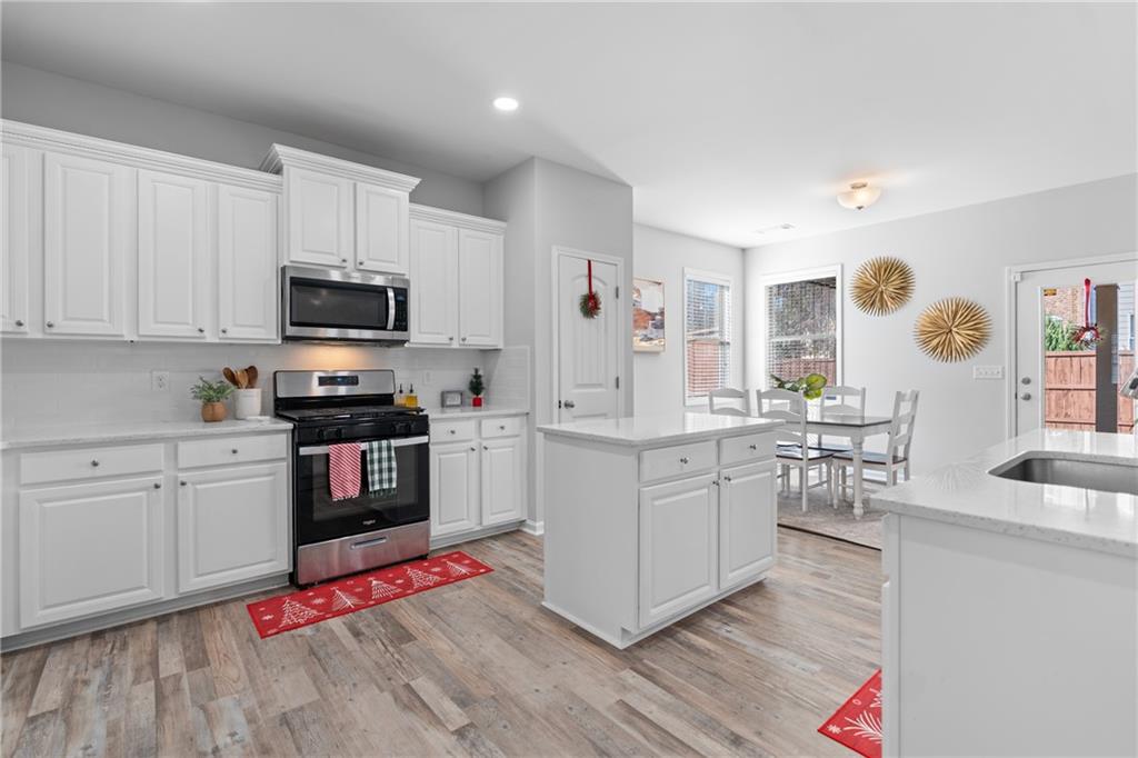 2190 Leatherstone Drive Powder Springs, GA 30127 - Photo 6 of 38 a kitchen with granite countertop a sink cabinets and stainless steel appliances
