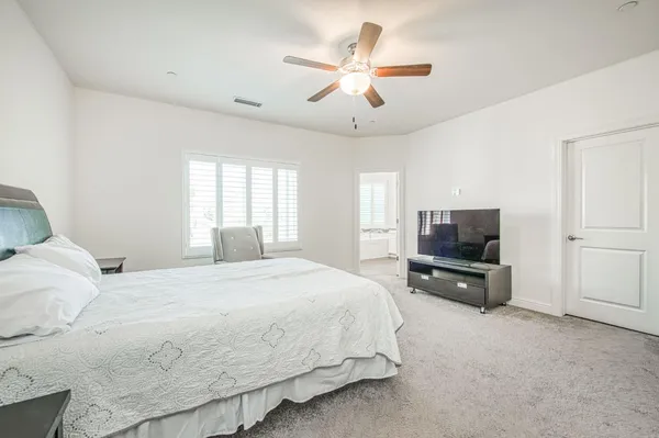 a bedroom with a large bed and a flat screen tv