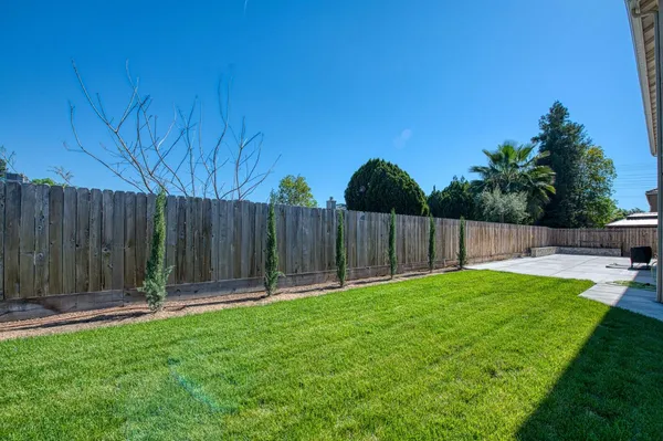 a backyard with table and chairs a fire pit and wooden fence