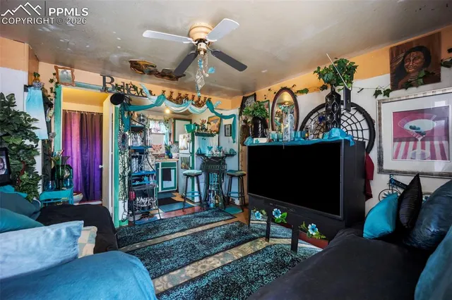 a living room with furniture a flat screen tv and a floor to ceiling window