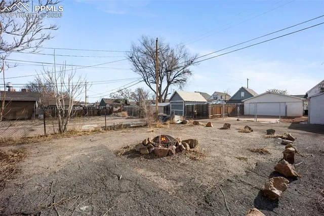 a view of a yard with a car parked in the road