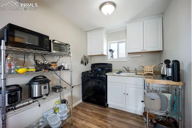 a kitchen with stainless steel appliances a stove a sink a microwave and wooden cabinets