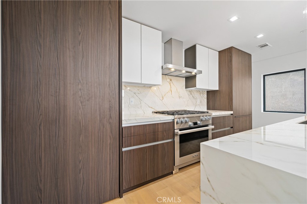 121 39th Street, Unit B Newport Beach, CA 92663 - Photo 9 of 26 a kitchen with stainless steel appliances granite countertop a stove and a refrigerator