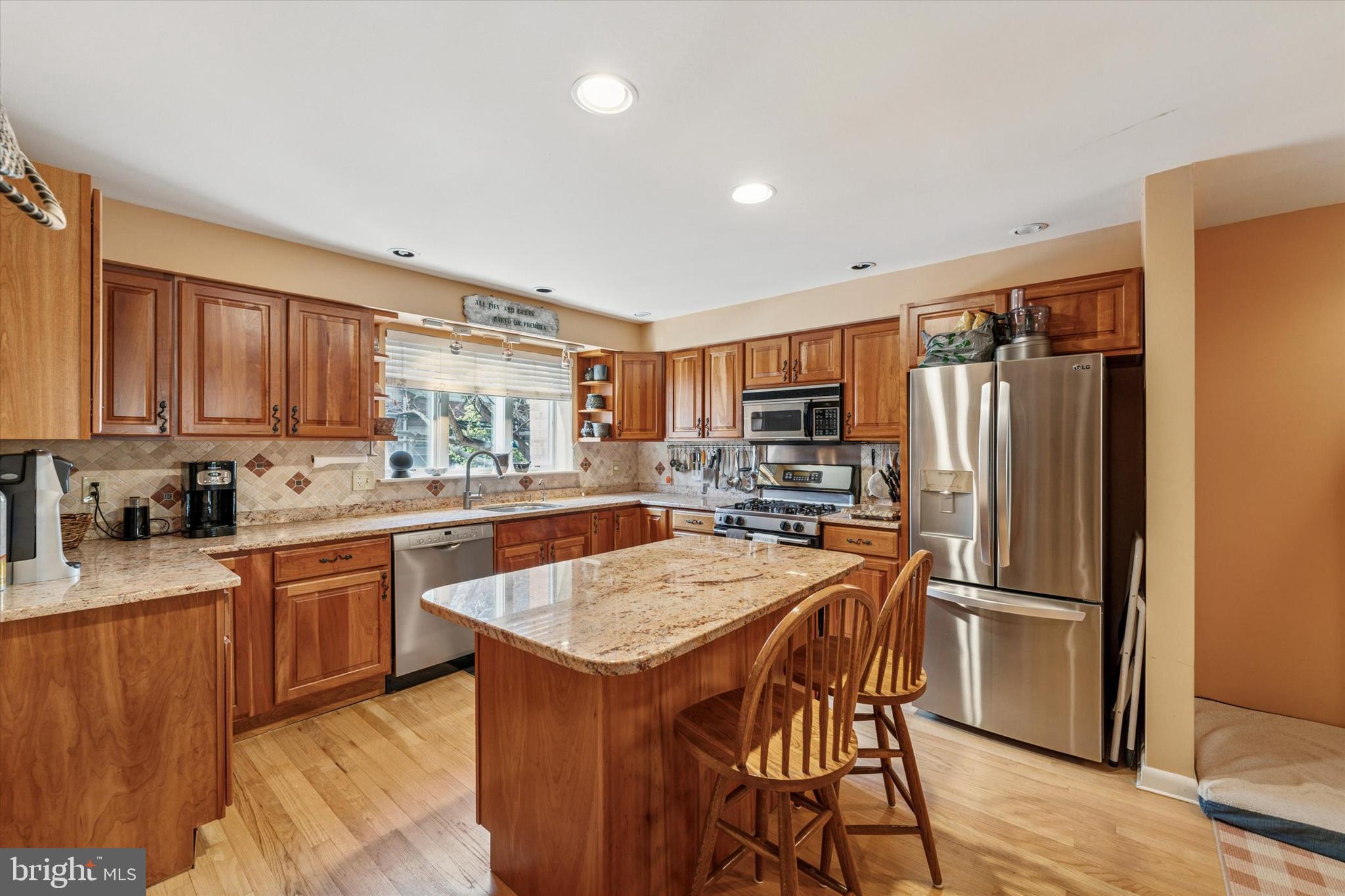 1 Christian Street, Unit 8 Philadelphia, PA 19147 - Photo 4 of 17 a kitchen with stainless steel appliances granite countertop a refrigerator a sink dishwasher a stove and white countertops with wooden floor