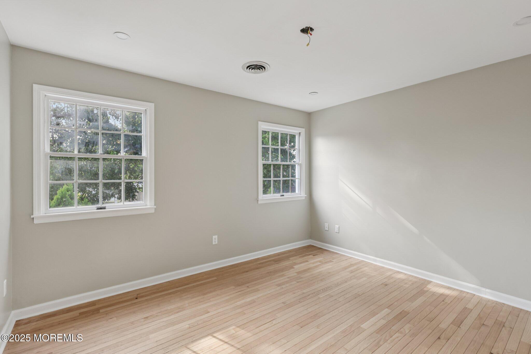 26 Fillmore Avenue Carteret, NJ 07008 - Photo 16 of 60 an empty room with wooden floor and windows