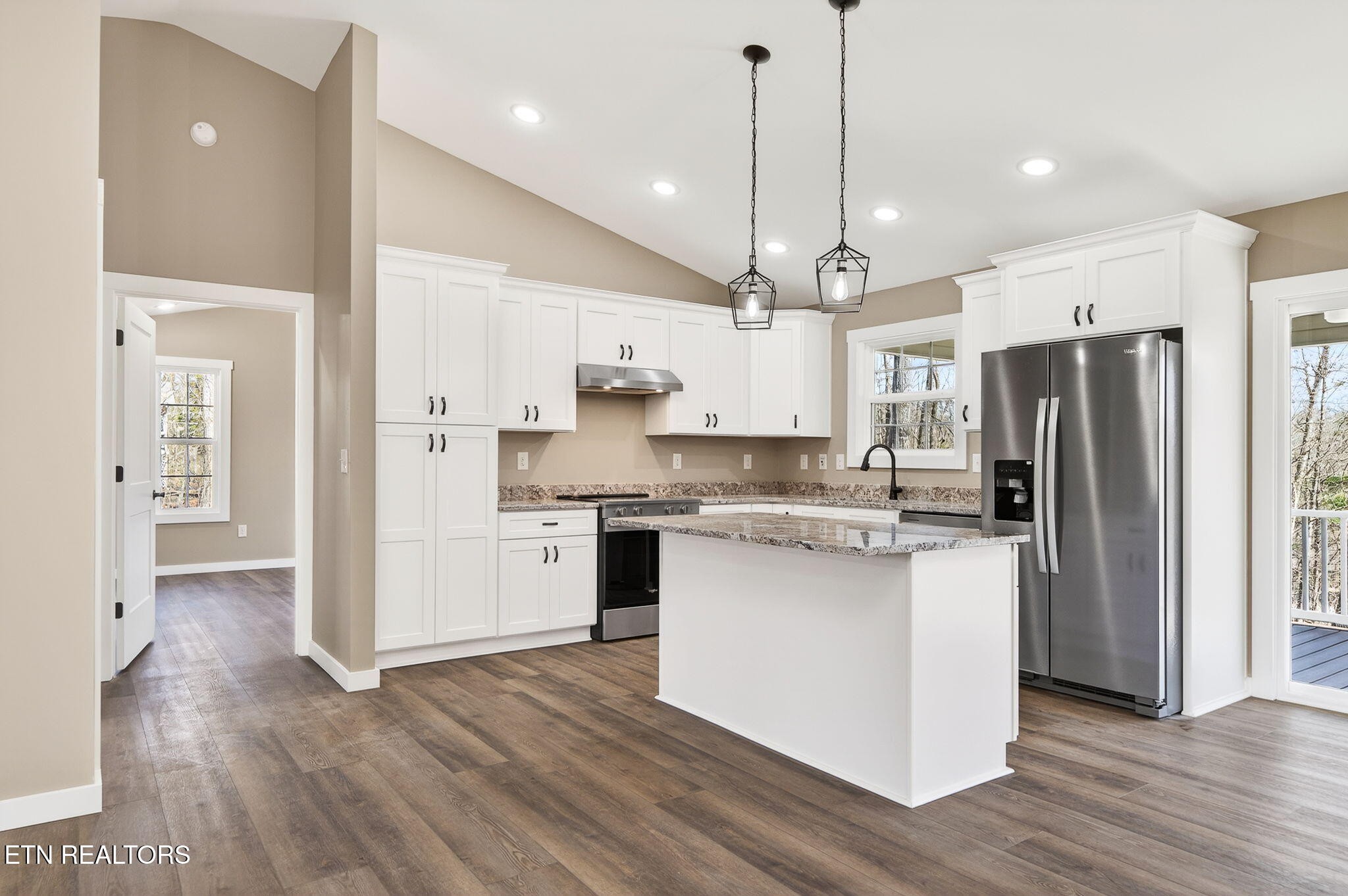 105 Peebles Road Crossville, TN 38558 - Photo 9 of 40 a kitchen with stainless steel appliances kitchen island a refrigerator a sink dishwasher a stove and white cabinets with wooden floor