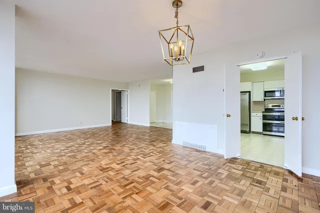 a view of a big room with wooden floor and windows