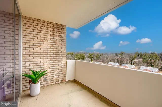 a view of a balcony with chairs and a potted plant