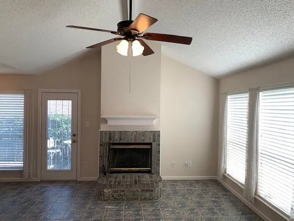 a view of a livingroom with a fireplace and window