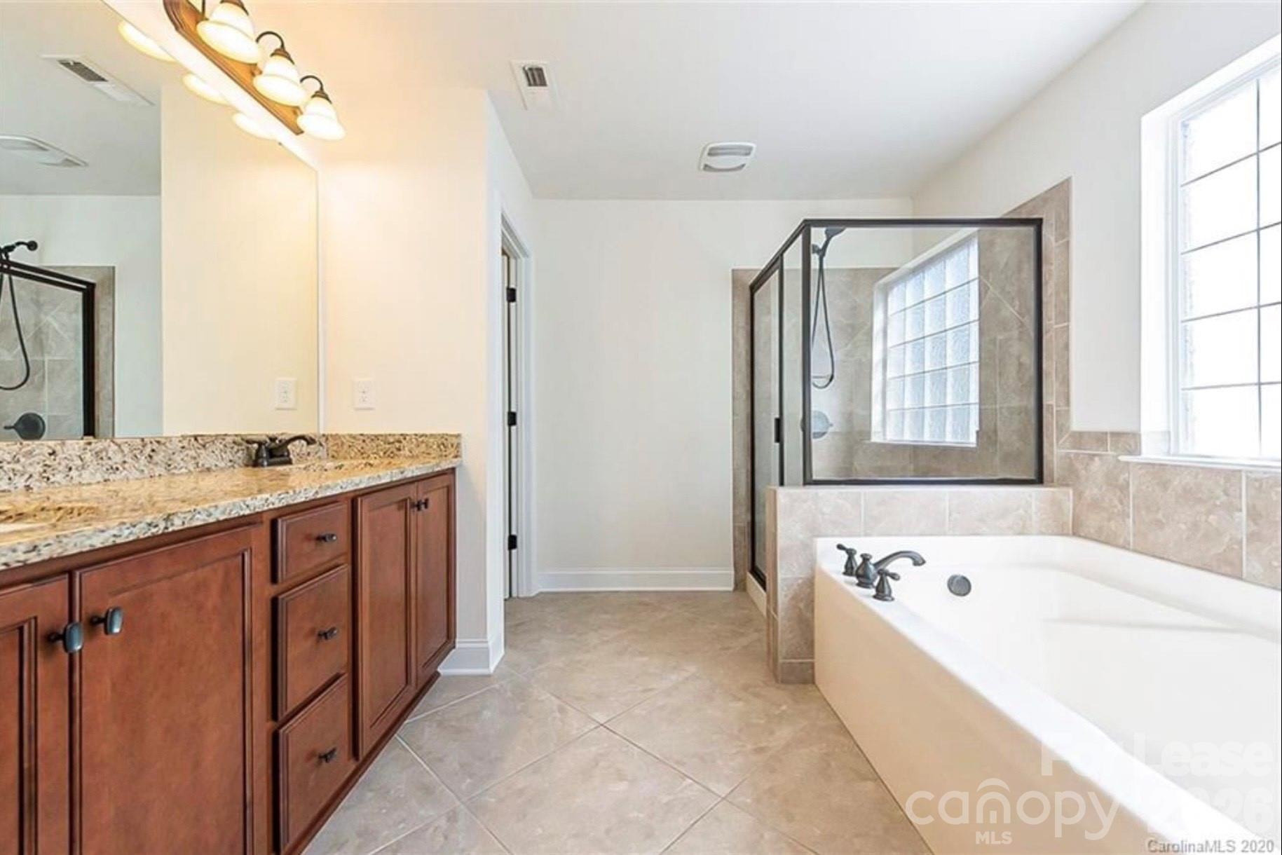 2003 Fallondale Road Waxhaw, NC 28173 - Photo 19 of 31 a spacious bathroom with a granite countertop tub sink and mirror