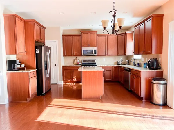 a view of a living room and kitchen with stainless steel appliances