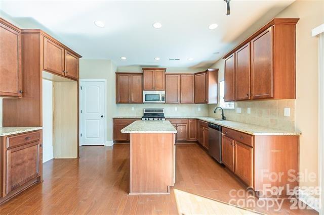 2003 Fallondale Road Waxhaw, NC 28173 - Photo 4 of 31 a kitchen with stainless steel appliances granite countertop a stove top oven a sink dishwasher and a refrigerator with wooden floor