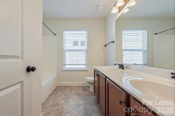 a bathroom with a granite countertop sink a toilet and shower