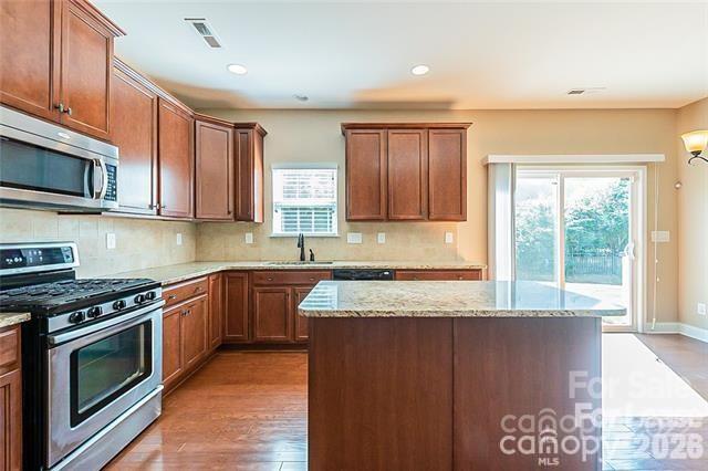 2003 Fallondale Road Waxhaw, NC 28173 - Photo 6 of 31 a kitchen with granite countertop a stove top oven cabinetry a sink and a microwave