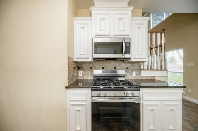 a kitchen with cabinets stainless steel appliances and a sink