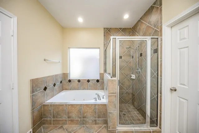 a bathroom with a granite countertop sink a mirror and shower