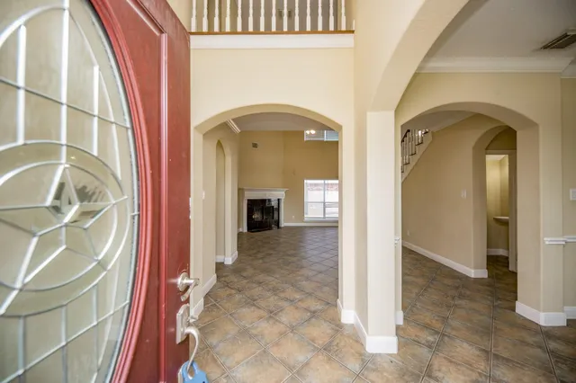 a view of a hallway with wooden floor and a living room