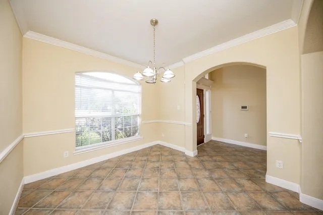 a view of a livingroom with a chandelier fan and windows