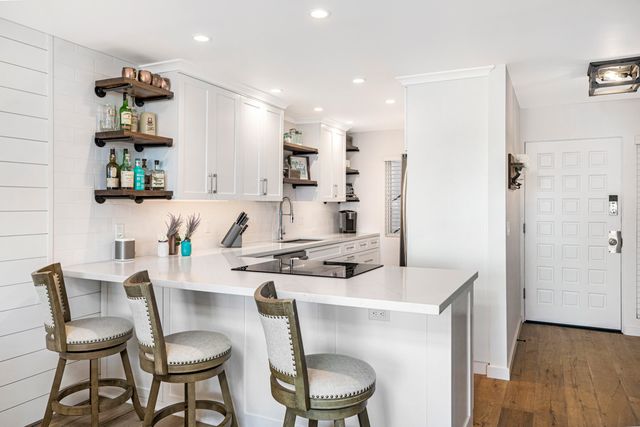 a kitchen with a dining table chairs and white cabinets