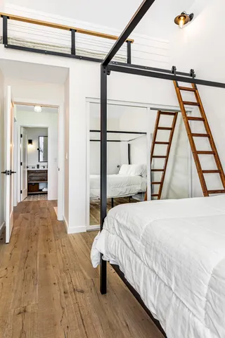 a bedroom with a bed and a large mirror on the dresser