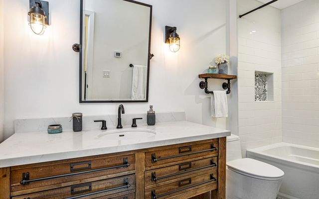 a bathroom with a sink a toilet and a mirror