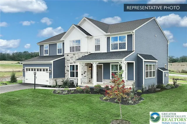 a front view of a house with a garden and yard