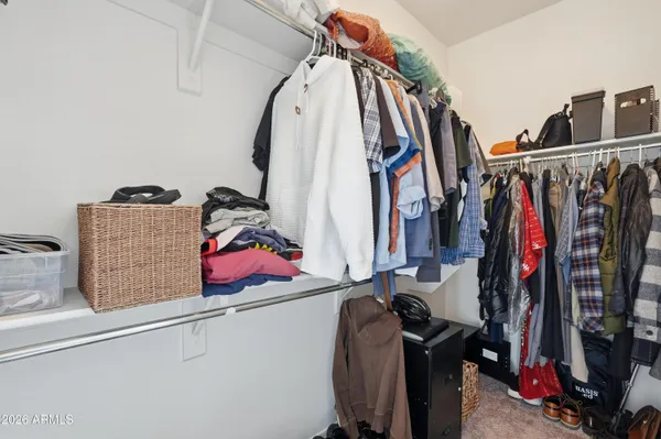 a view of walk in closet with clothes