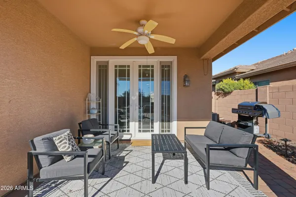 a patio with a table and chairs and potted plants