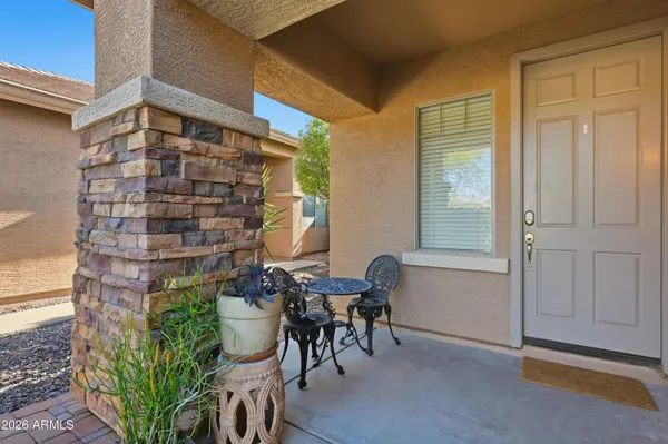 a patio with table and chairs and potted plants