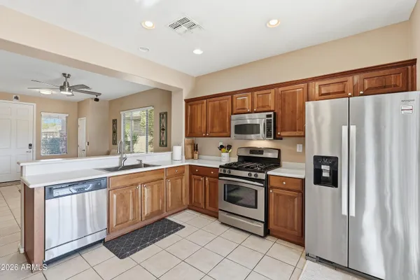 a kitchen with stainless steel appliances granite countertop a refrigerator and a stove top oven