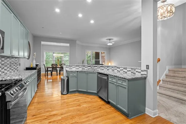 a kitchen with stainless steel appliances granite countertop a sink stove and refrigerator