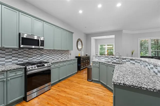 a kitchen with stainless steel appliances granite countertop a sink stove and refrigerator