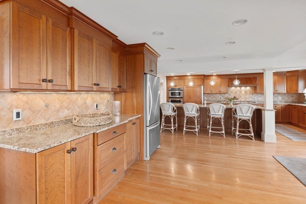10 Union Street Hingham, MA 02043 - Photo 8 of 40 a kitchen with stainless steel appliances granite countertop a stove top oven a sink with dining table and chairs