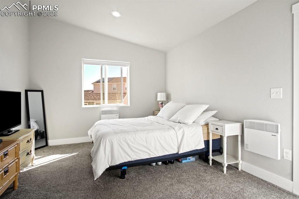10052 Bracknell Place Peyton, CO 80831 - Photo 22 of 36 a bedroom with a bed and a flat tv screen on a dresser