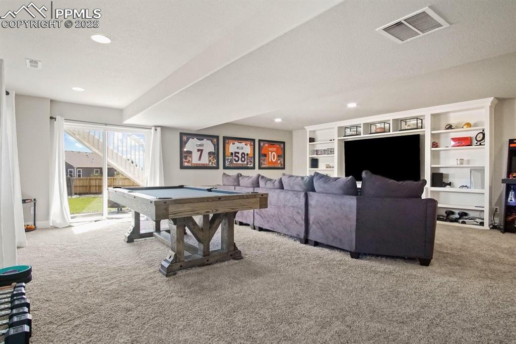 10052 Bracknell Place Peyton, CO 80831 - Photo 23 of 36 a living room with furniture and a flat screen tv