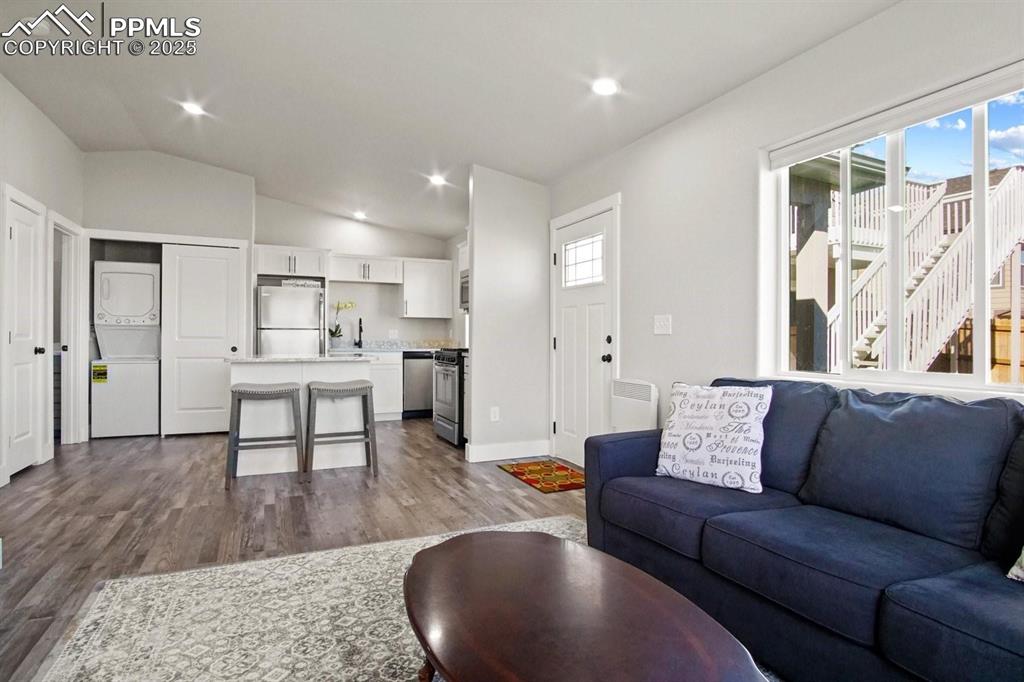 10052 Bracknell Place Peyton, CO 80831 - Photo 31 of 36 a living room kitchen with a couch and a wooden floor