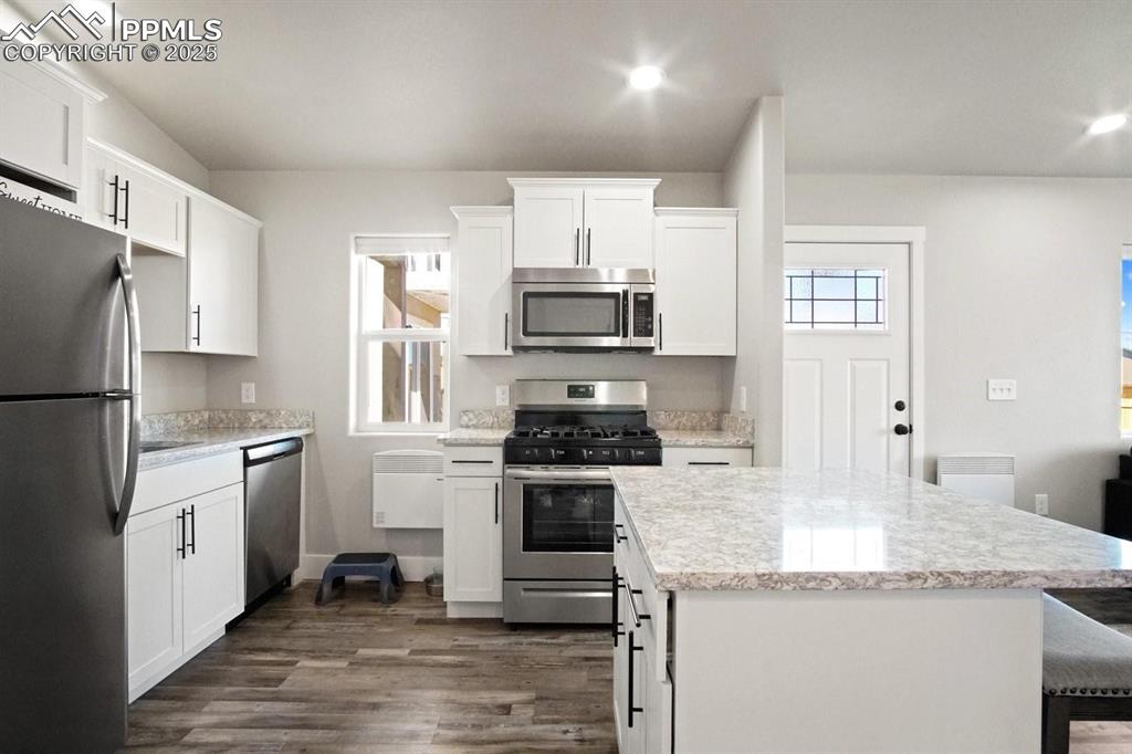 10052 Bracknell Place Peyton, CO 80831 - Photo 34 of 36 a kitchen with granite countertop a stove sink and refrigerator