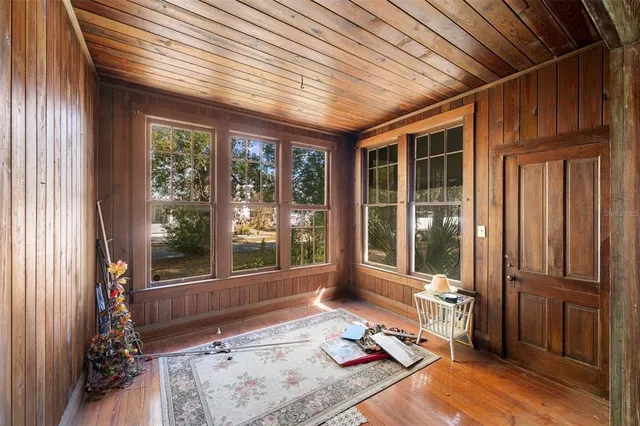 a living room with hardwood floor and large windows