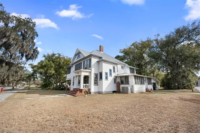 a view of a white house with a yard