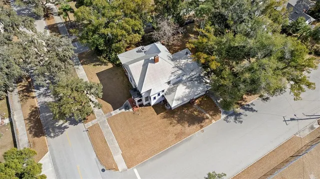 an aerial view of a house with a yard and trees