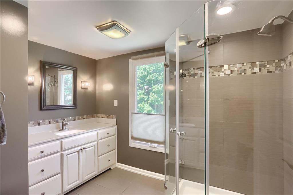 3275 Ridge Rd Extension Freedom, PA 15042 - Photo 18 of 25 Wow, spa like bath features heated tile flooring, an over sized vanity with tile detailing, a large tile shower and a sun filled window.