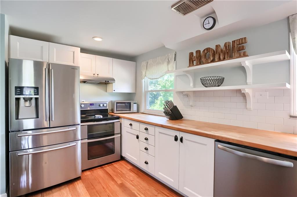 3275 Ridge Rd Extension Freedom, PA 15042 - Photo 7 of 25 Stainless steel appliances compliment the sleek white cabinetry and butcher block counters.