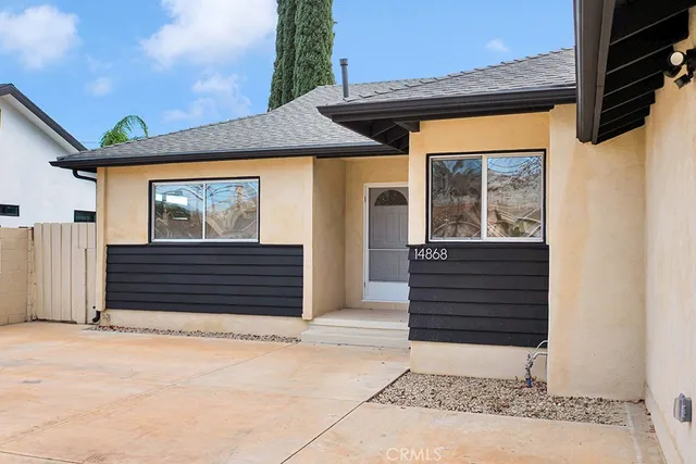 a front view of a house with a garden and yard