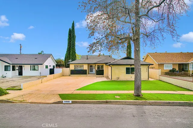 a view of a house with backyard and wooden fence