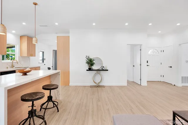 a kitchen with kitchen island a counter top space a sink stainless steel appliances and cabinets