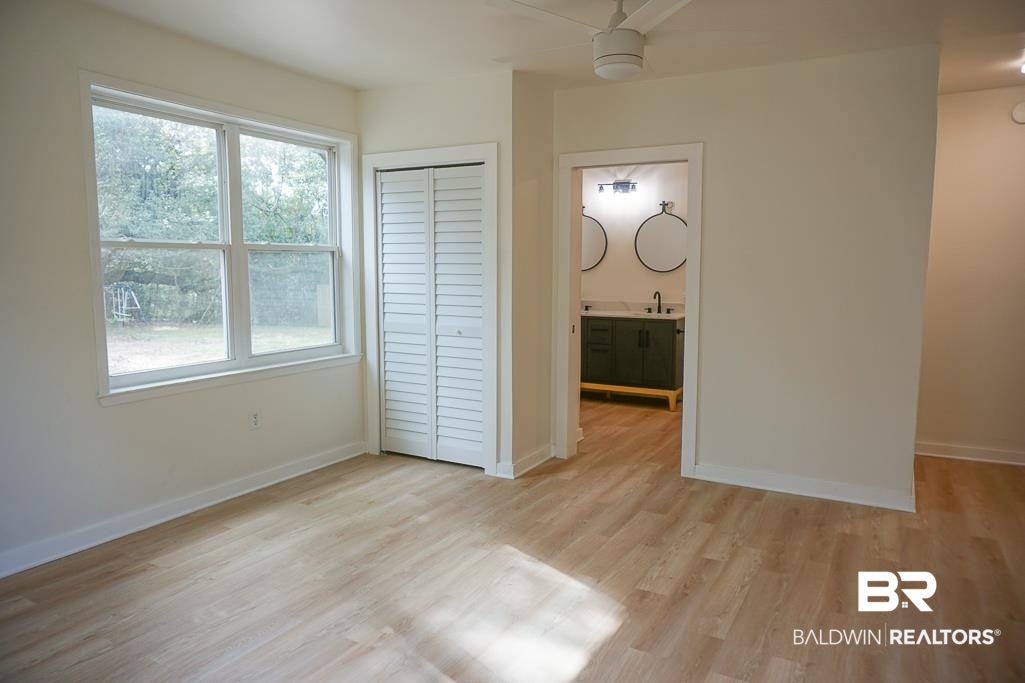 4667 Cottonwood Drive Mobile, AL 36608 - Photo 13 of 21 Unfurnished bedroom featuring a closet, light hardwood / wood-style floors, multiple windows, and ceiling fan